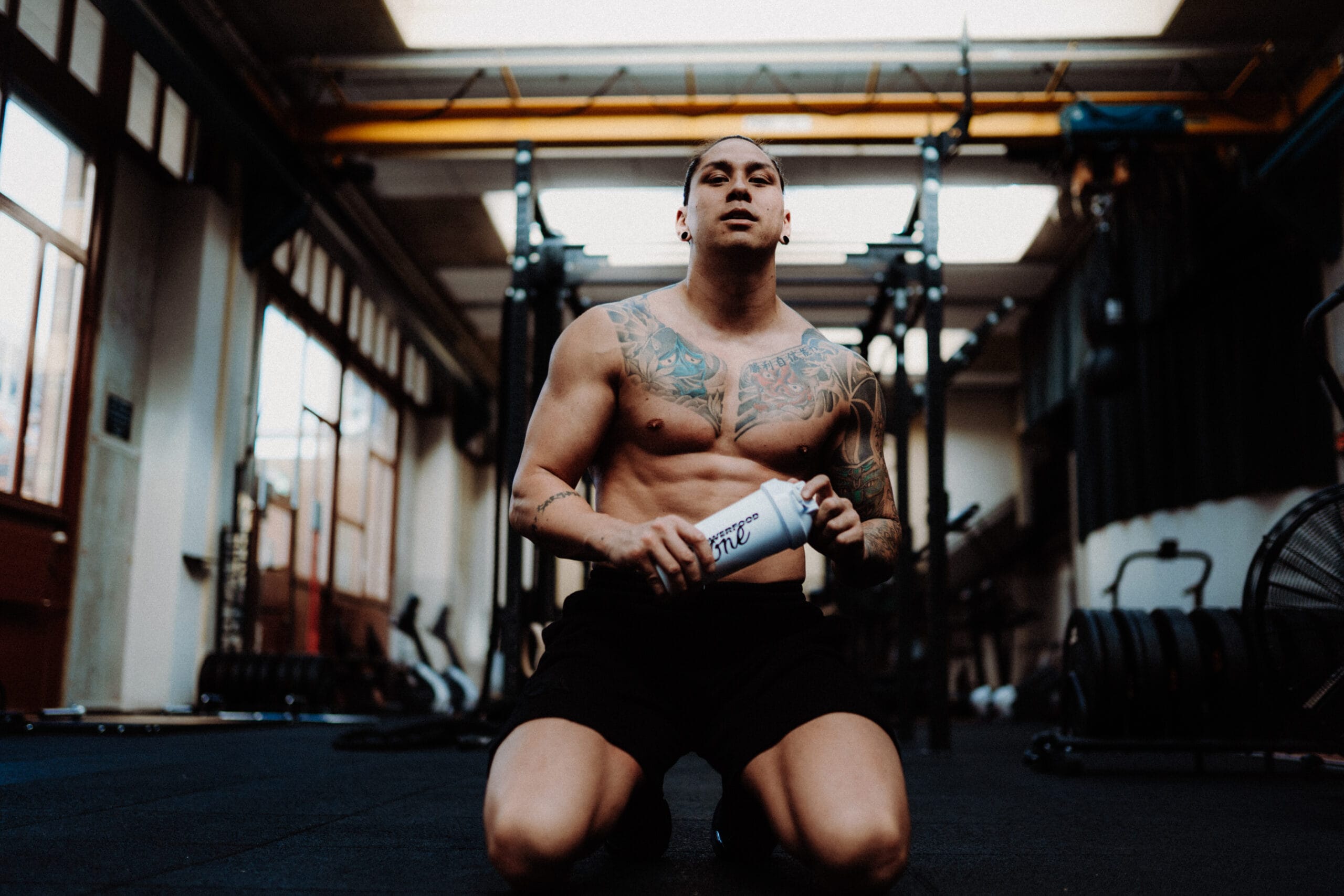 Sportovec po silovém tréninku pije proteinový nápoj Boom Whey PowerFood – kvalitní syrovátkový protein pro regeneraci a budování svalové hmoty