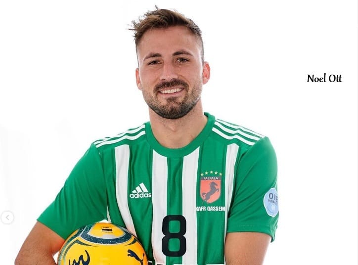 Fotbalista při portrétním focení v klubovém dresu s míčem